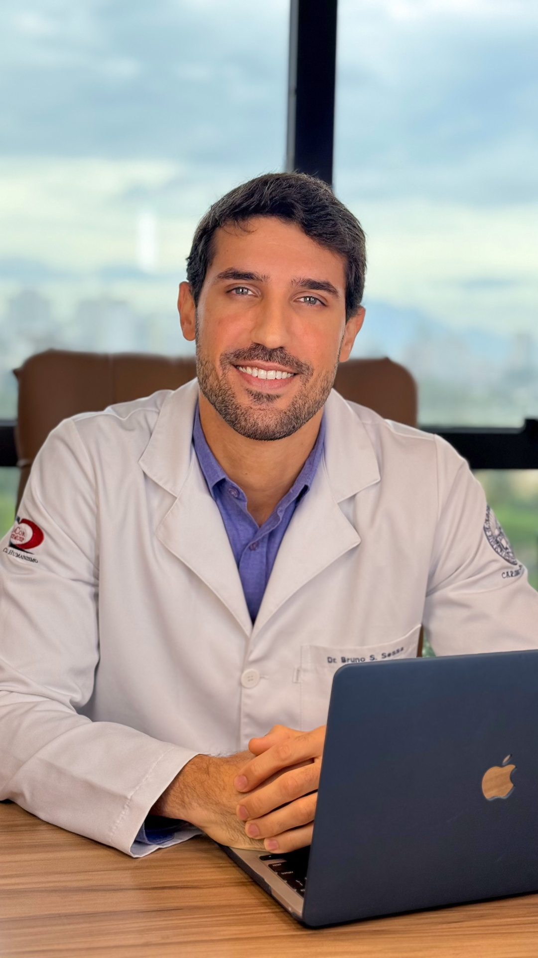 Dr. Bruno Sessa sorrindo, de jaleco branco